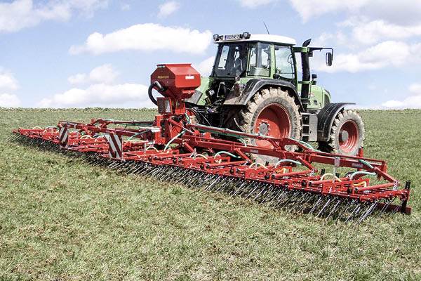 Ogräsharv bakom en traktor på ett fält