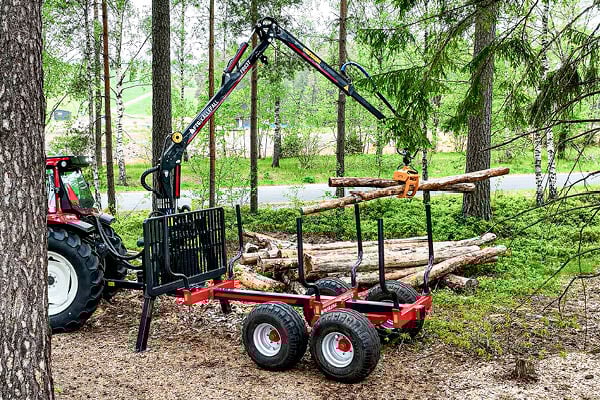 Skogsvagn med timmer lastad i skogen.
