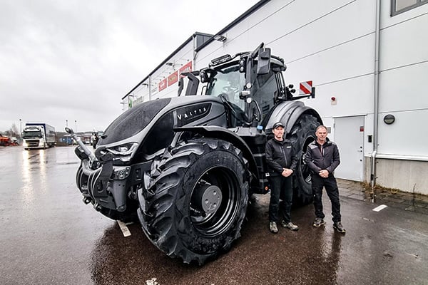 Två män står framför en traktor (Valtra)